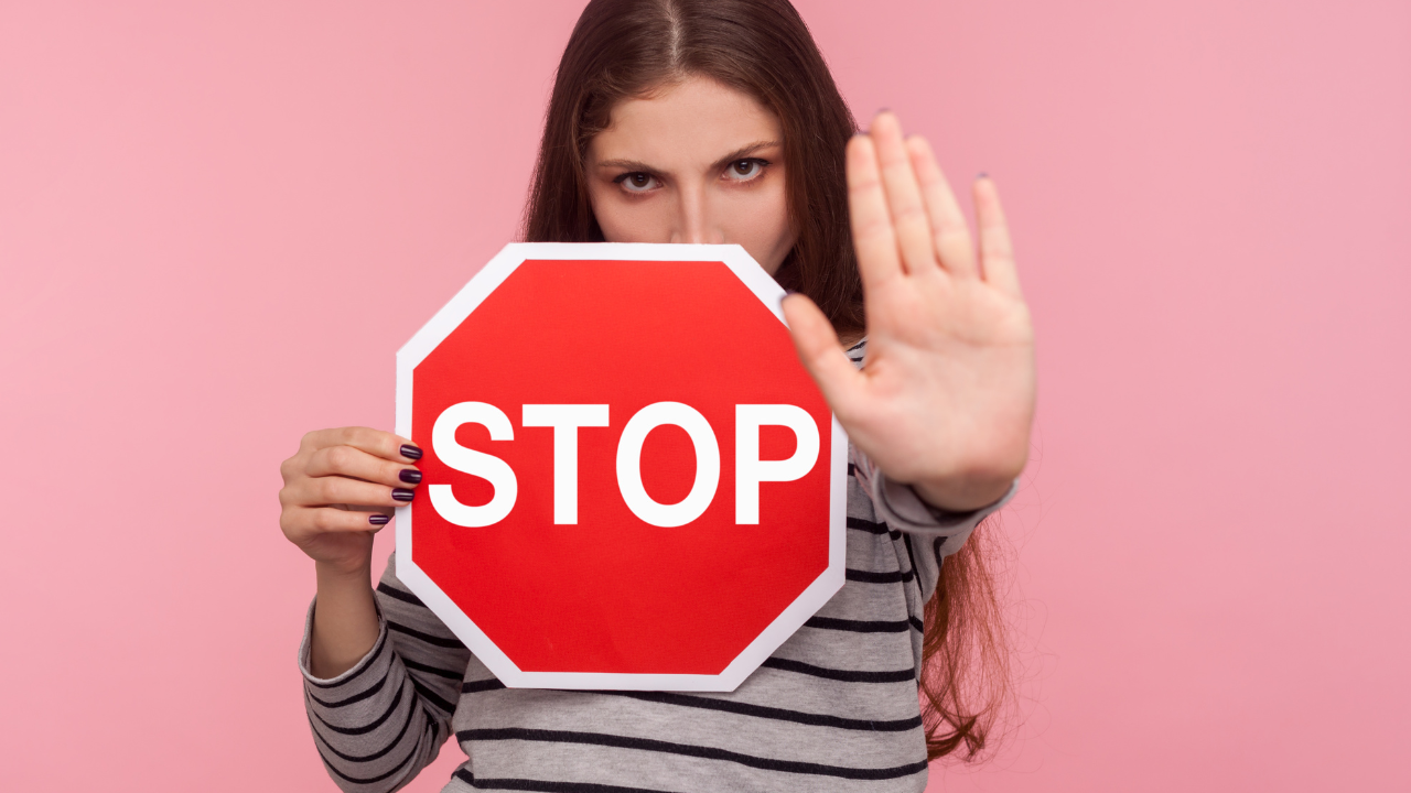 「STOP」と書かれた板を持った女性